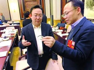 昨天,北京團小組會(hui) 休息的間隙,程京代表(右)向夏林茂代表介紹基因芯片。張宇攝